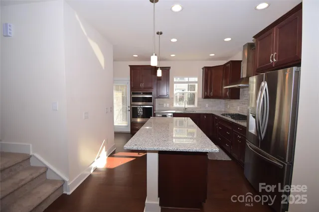 a kitchen with stainless steel appliances a refrigerator and a stove top oven