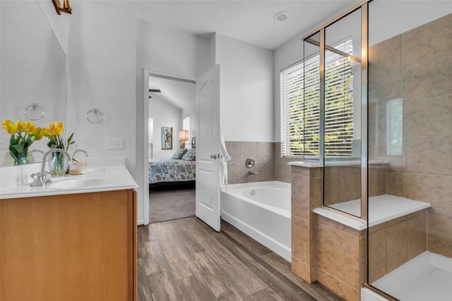 a en suite spacious bathroom with a tub shower and a sink