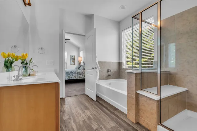 a en suite spacious bathroom with a tub shower and a sink