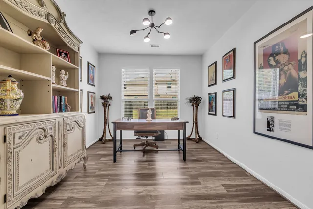 a dining room with wooden floor a chandelier a glass table and windows