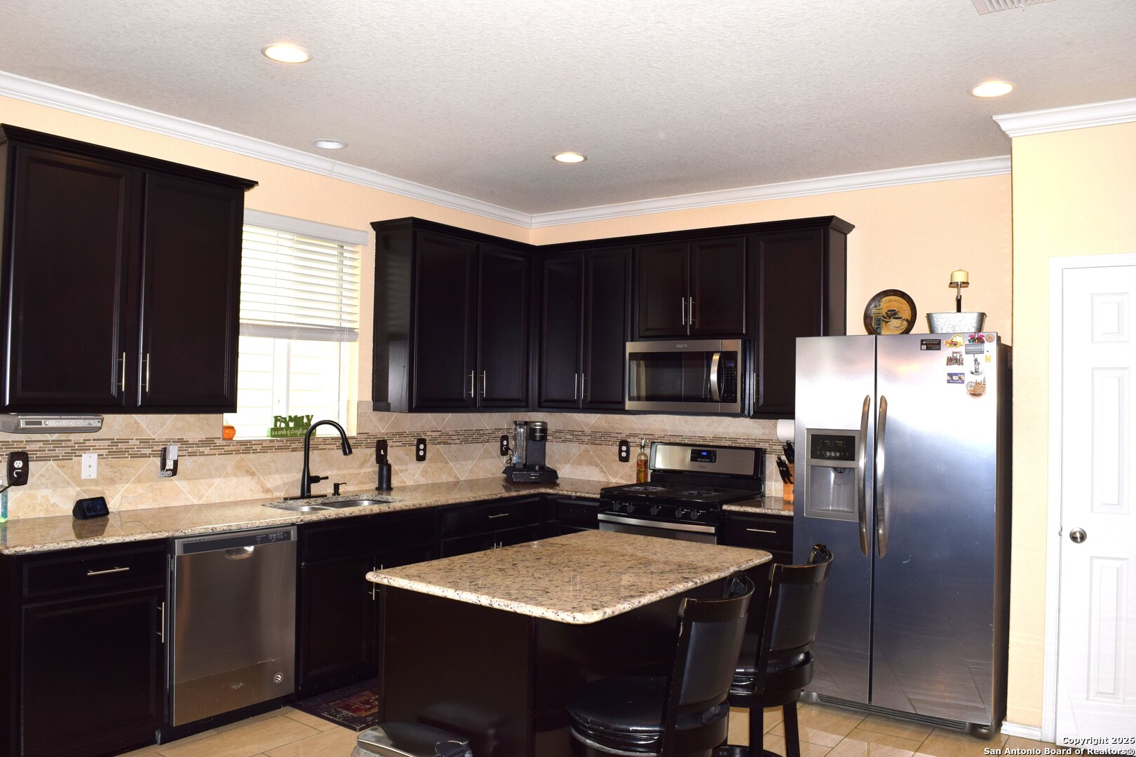 7215 Capricorn Way Converse, TX 78109 - Photo 7 of 22 a kitchen with stainless steel appliances granite countertop a sink refrigerator and microwave