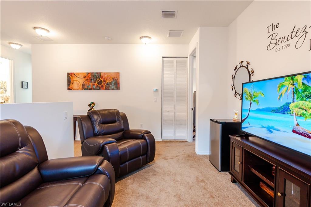 5092 Beckton Road Ave Maria, FL 34142 - Photo 19 of 36 a living room with furniture and a flat screen tv