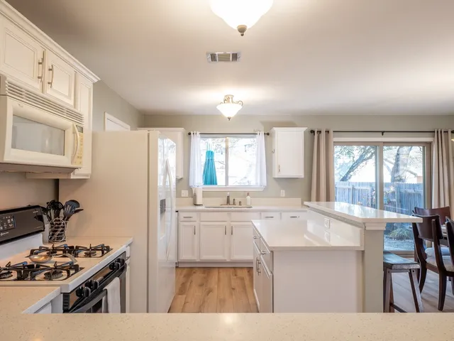 a kitchen with stainless steel appliances a sink stove and cabinets