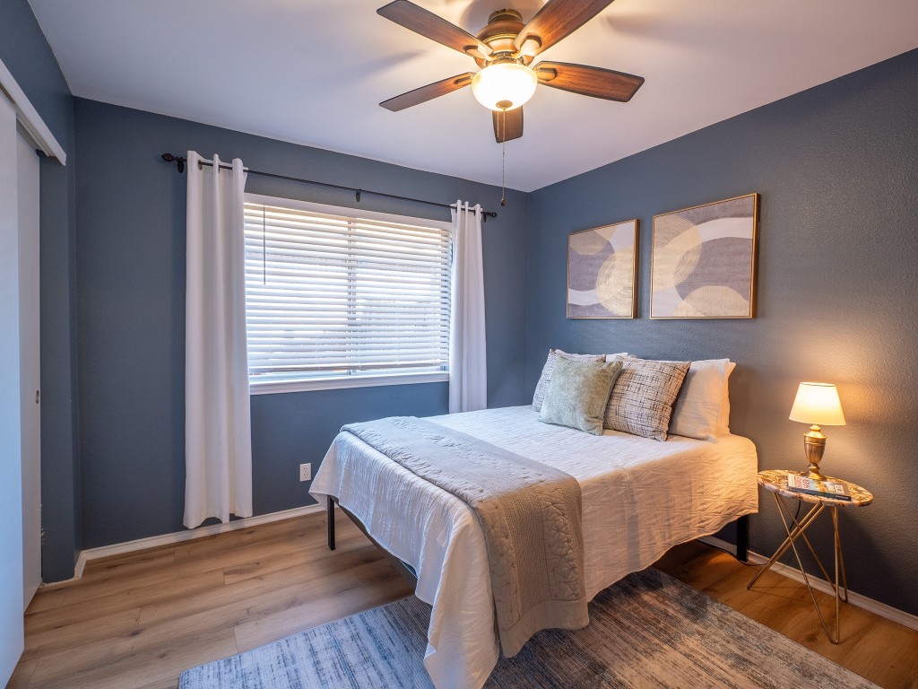 9610 Dalewood Drive Austin, TX 78729 - Photo 17 of 27 a bedroom with a large bed chandelier and a window
