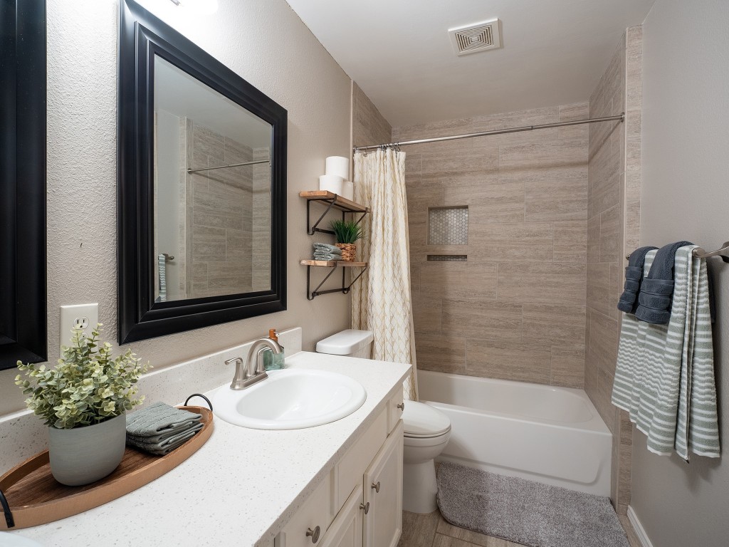 9610 Dalewood Drive Austin, TX 78729 - Photo 23 of 27 a bathroom with a granite countertop sink a toilet a shower and a bathtub