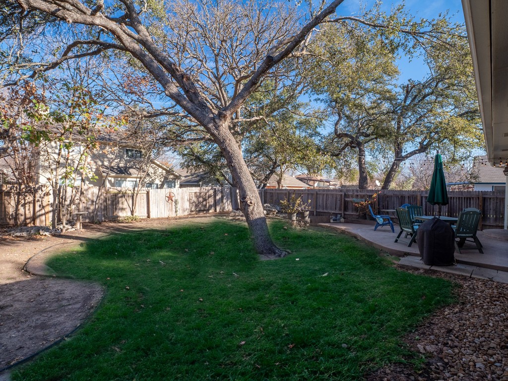 9610 Dalewood Drive Austin, TX 78729 - Photo 25 of 27 a view of a backyard with table and chairs and a large tree