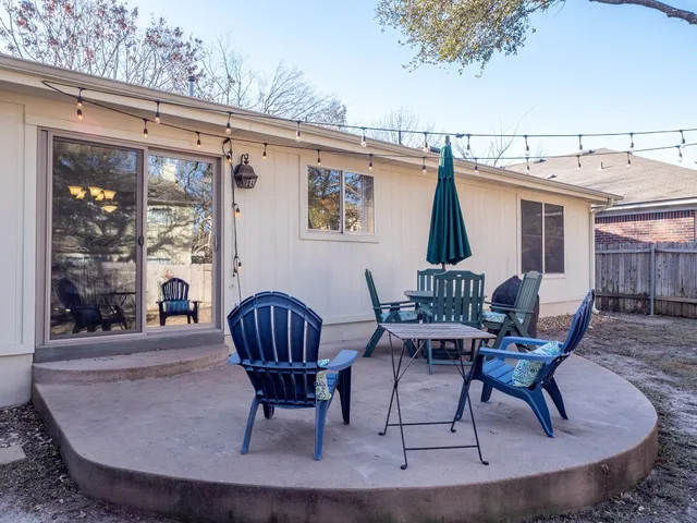 a view of a backyard with table and chairs and a large tree
