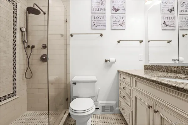 a bathroom with a granite countertop sink toilet and shower