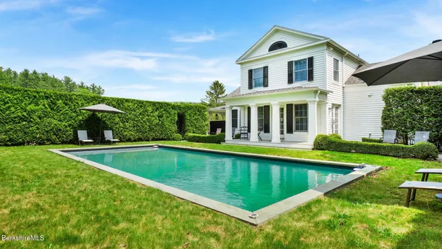 a view of an house with swimming pool and yard