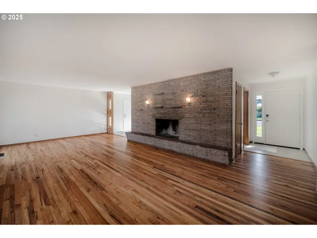 a view of an empty room and wooden floor