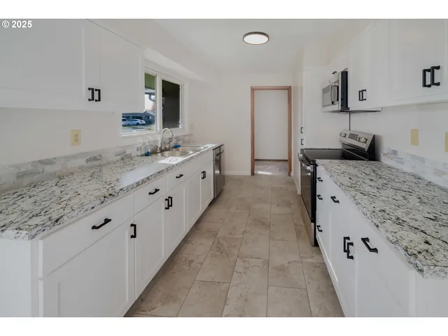 a kitchen with sink stove and refrigerator