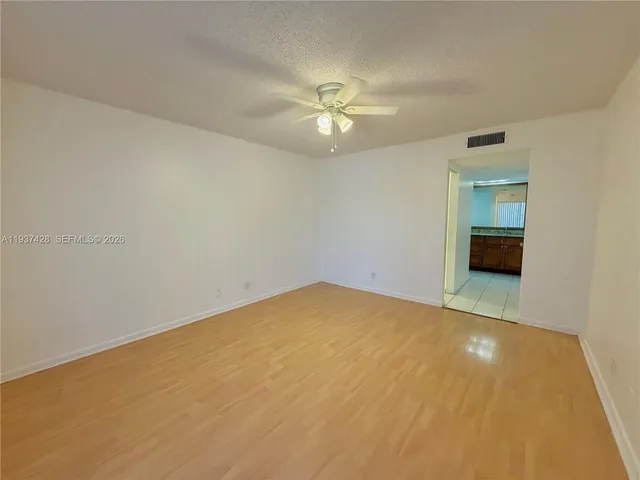 an empty room with a ceiling fan and a window