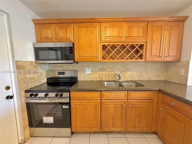 a kitchen with stainless steel appliances wooden cabinets and a stove top oven