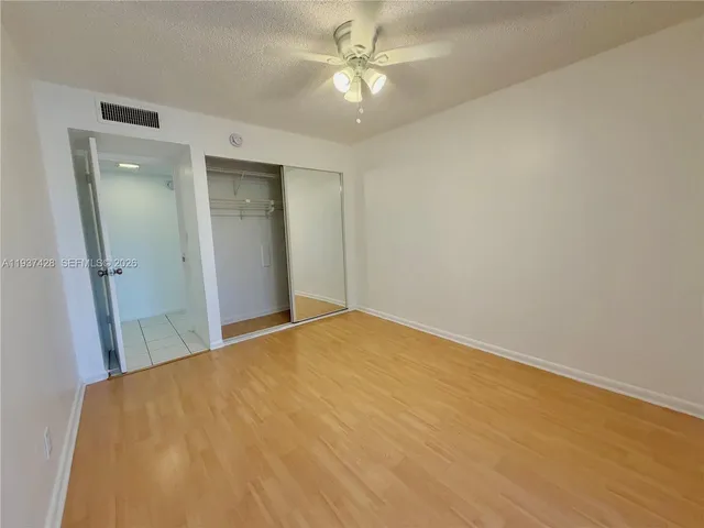 a view of a big room with closet and a ceiling fan