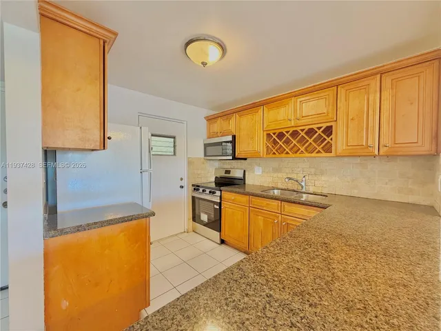 a kitchen with stainless steel appliances granite countertop a sink and cabinets
