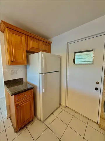 a kitchen with granite countertop a refrigerator and a stove top oven