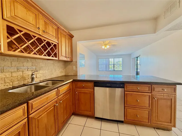 a kitchen with granite countertop cabinets and white appliances