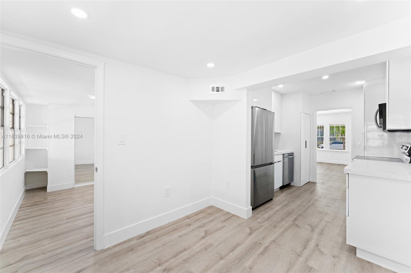 3155 Southwest 27th Lane, Unit 1 Miami, FL 33133 - Photo 14 of 18 a kitchen with a refrigerator and white cabinets