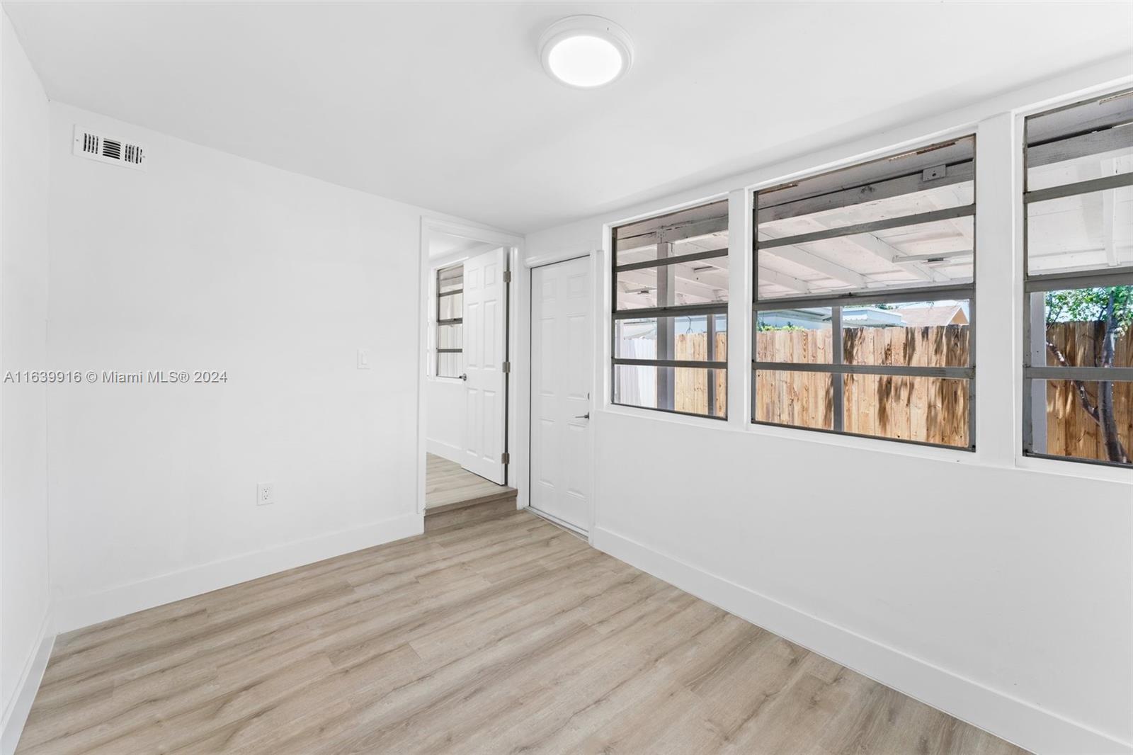 3155 Southwest 27th Lane, Unit 1 Miami, FL 33133 - Photo 16 of 18 wooden floor in an empty room with a window