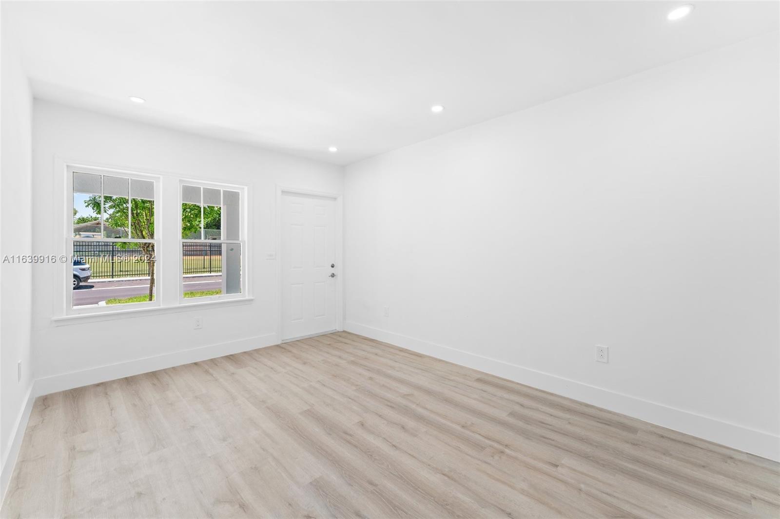 3155 Southwest 27th Lane, Unit 1 Miami, FL 33133 - Photo 6 of 18 an empty room with wooden floor and windows