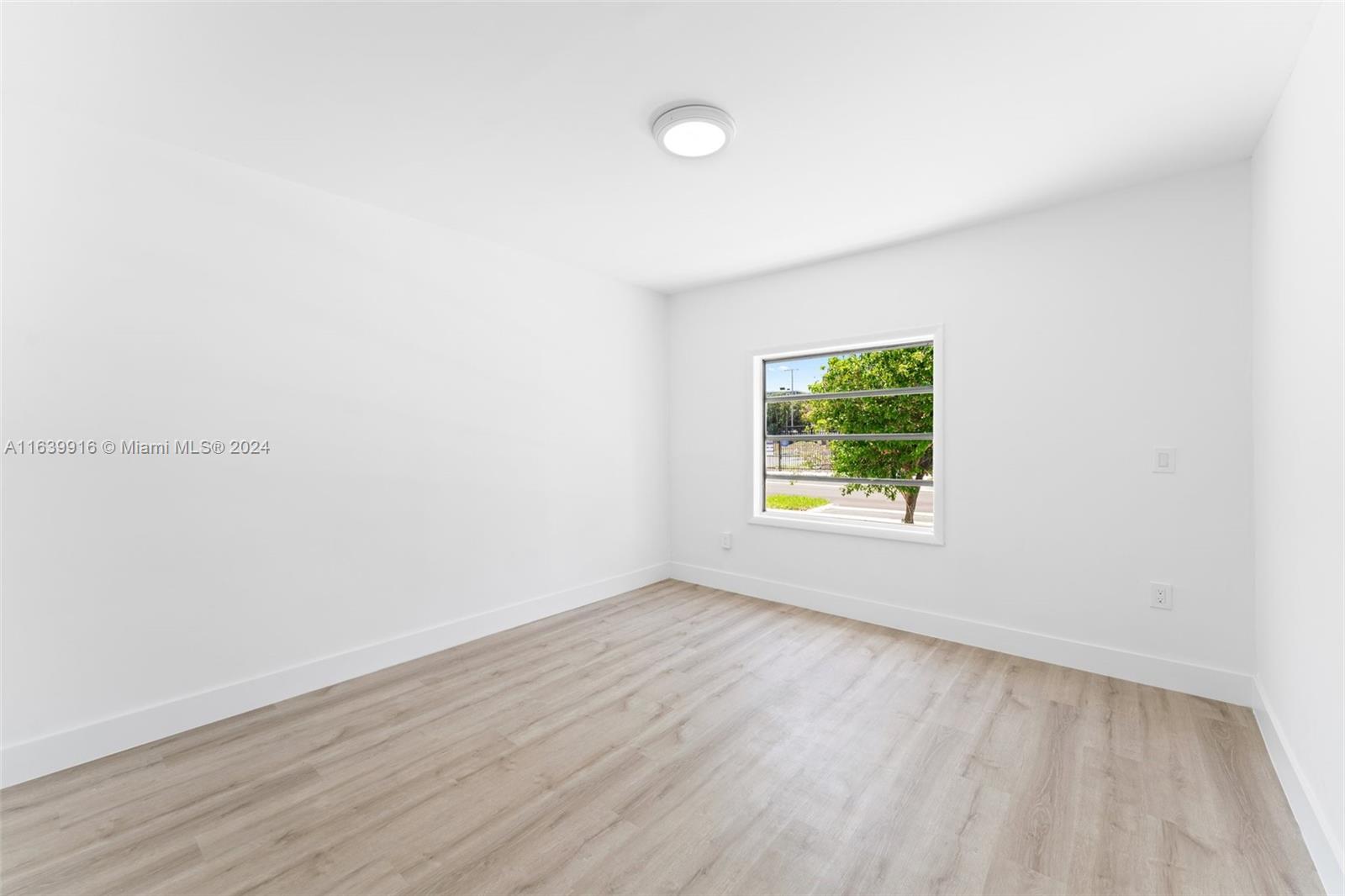 3155 Southwest 27th Lane, Unit 1 Miami, FL 33133 - Photo 9 of 18 an empty room with wooden floor and windows