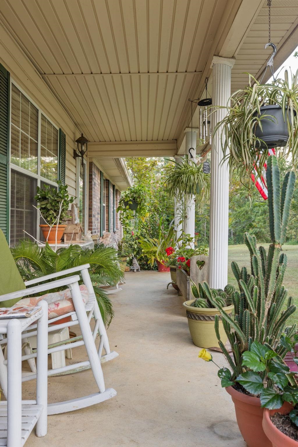 116 County Road 713 Corinth, MS 38834 - Photo 25 of 40 a view of a patio with table and chairs potted plants and floor to ceiling window
