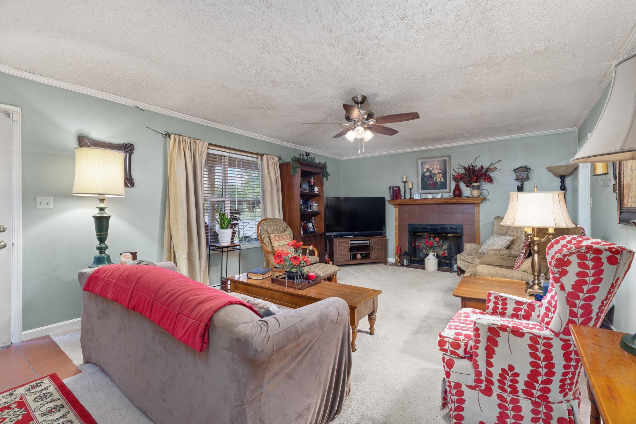 116 County Road 713 Corinth, MS 38834 - Photo 27 of 40 a living room with furniture a fireplace and a flat screen tv