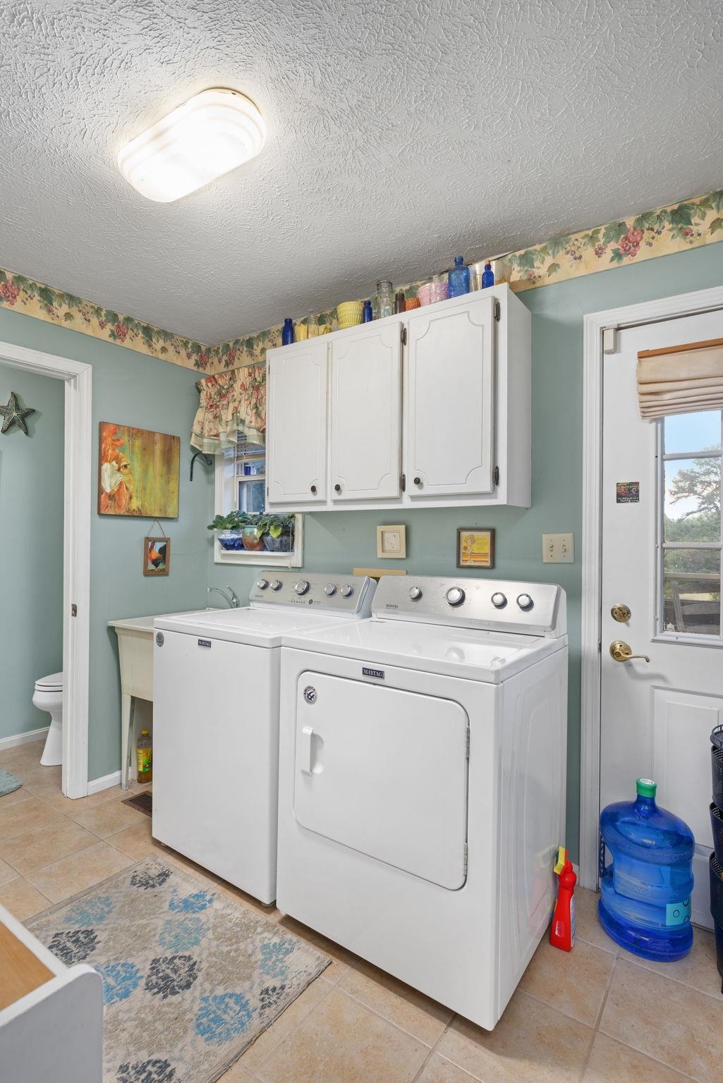 116 County Road 713 Corinth, MS 38834 - Photo 39 of 40 Laundry room with light tile patterned flooring, a textured ceiling, washer and dryer, and cabinet space