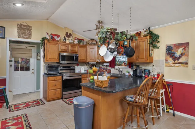 a kitchen filled with stainless steel appliances granite countertop a stove and a dining table