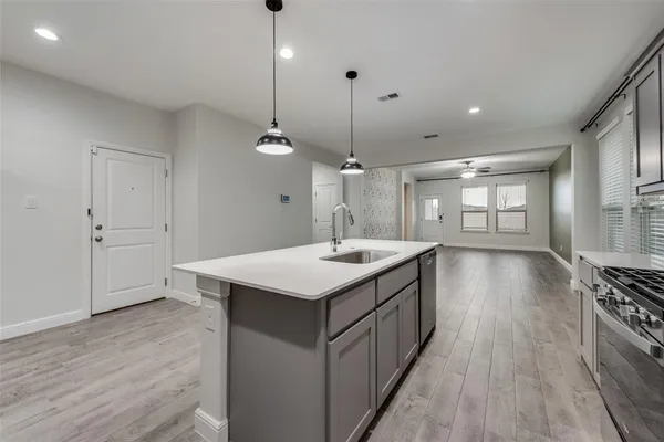 a kitchen with stove a sink and refrigerator