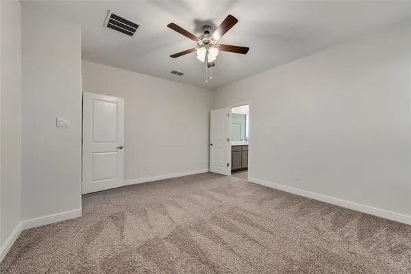 an empty room with closet and a ceiling fan