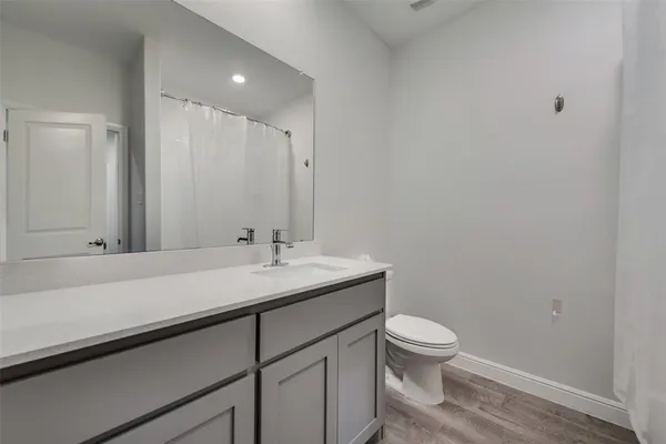 a bathroom with a granite countertop sink a toilet and a mirror