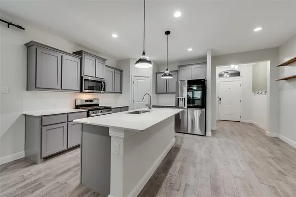 a kitchen with kitchen island a sink stainless steel appliances and cabinets