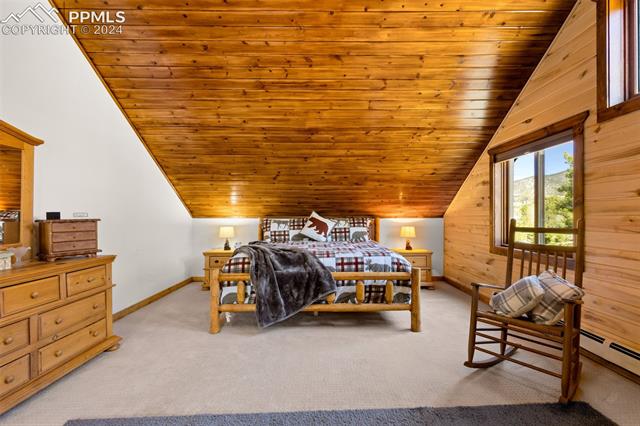 211 Yarnell Road Lake George, CO 80827 - Photo 22 of 50 Carpeted bedroom with wooden walls, lofted ceiling, and wood ceiling