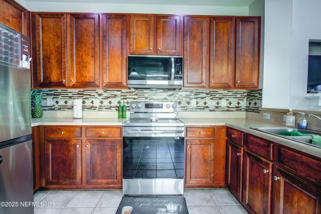 a kitchen with stainless steel appliances granite countertop wooden cabinets a sink and a stove