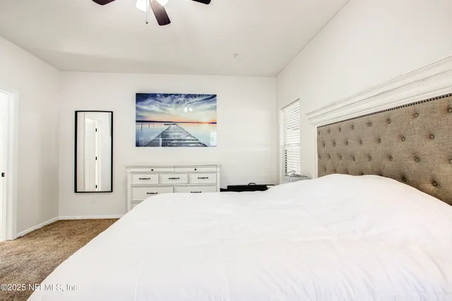 a bedroom with a bed and a painting on the wall
