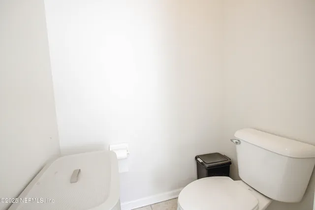 a white toilet sitting next to a shower