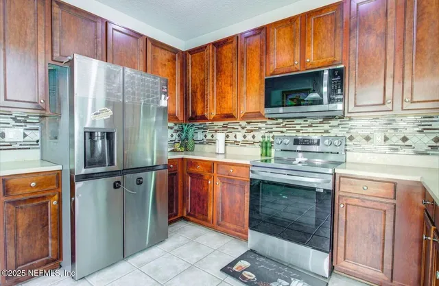 a kitchen with stainless steel appliances granite countertop a refrigerator stove and sink