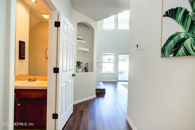 a view of a hallway with wooden floor and a living room