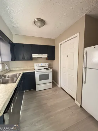 a kitchen with stainless steel appliances a refrigerator sink and stove