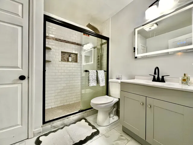 a bathroom with a sink a toilet and shower