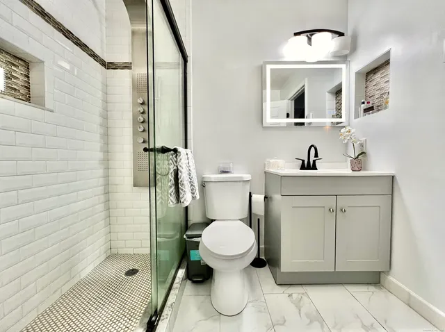a bathroom with a toilet sink and mirror
