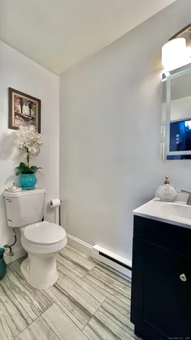 a bathroom with a toilet a sink and mirror