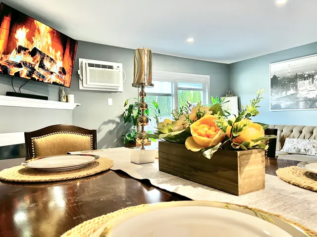 a living room with furniture a floor to ceiling window and a flat screen tv