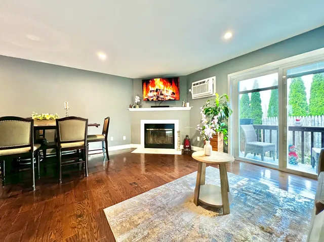a dining room with furniture a fireplace and wooden floor