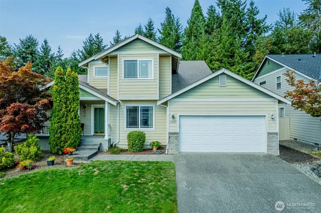 a front view of a house with a garden and plants