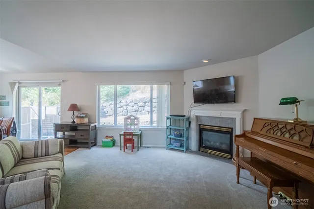 a living room with furniture a fireplace and a flat screen tv