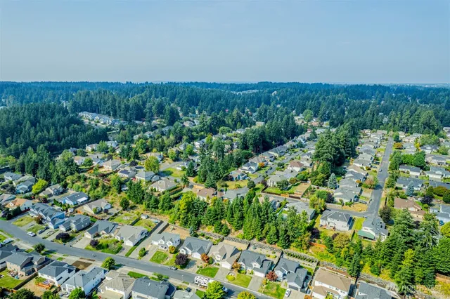 an aerial view of residential house with outdoor space and trees all around