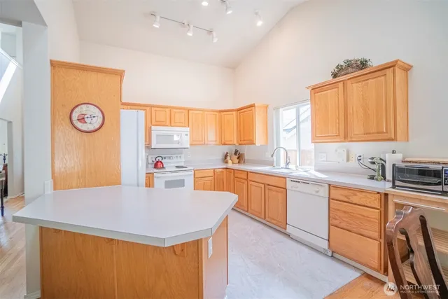 a kitchen with a sink a stove a refrigerator and wooden cabinets