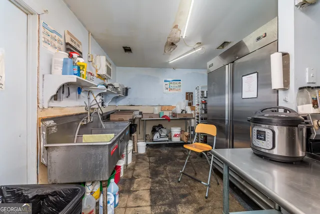 a kitchen with stainless steel appliances kitchen island granite countertop a table chairs stove and cabinets